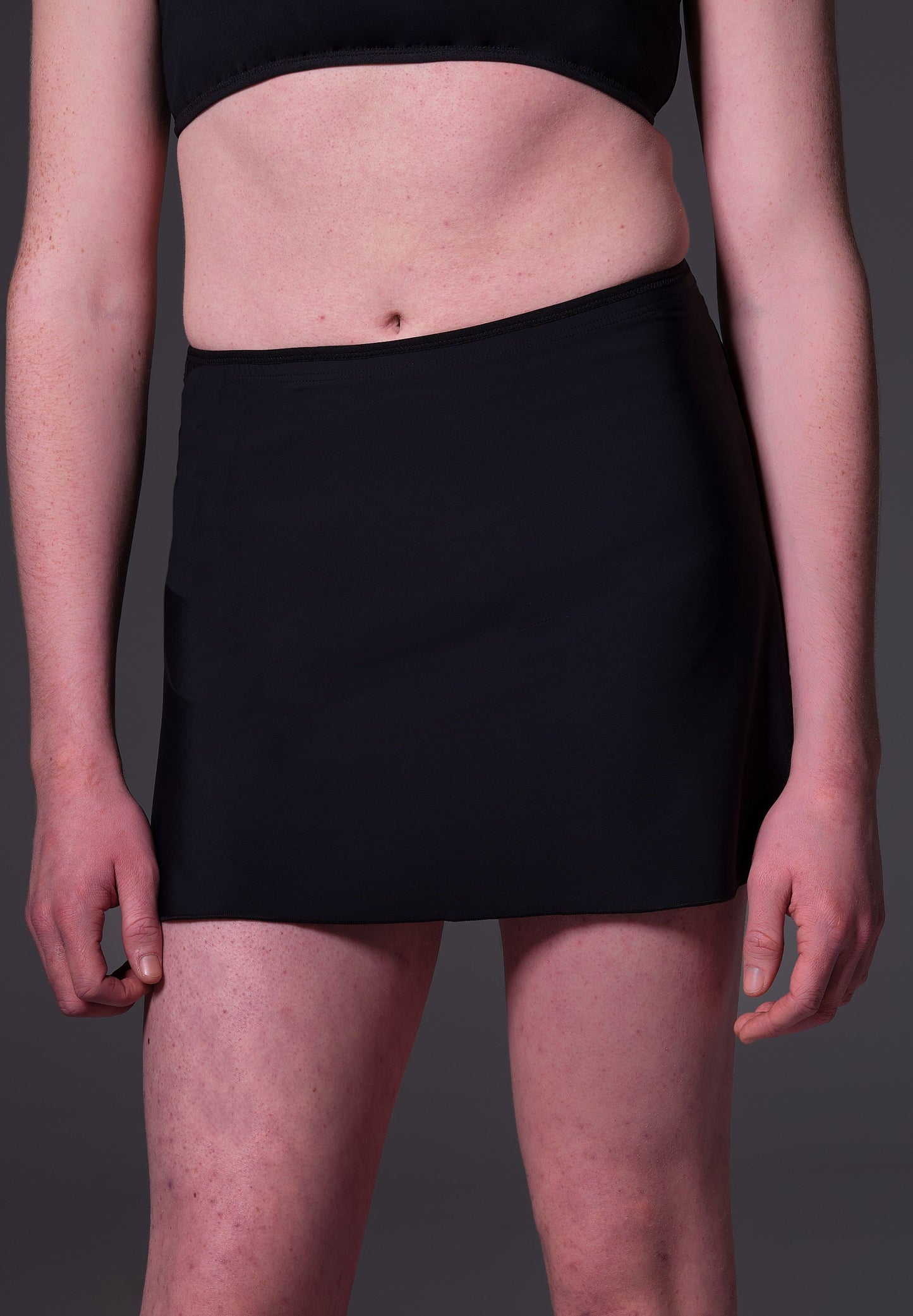 Front close-up of model Sweder, wearing the Swim Skirt black