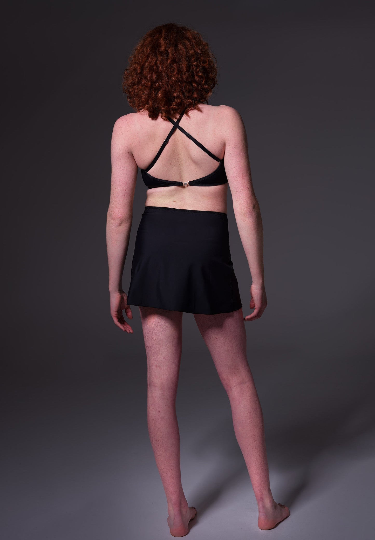 Model Sweder, seen from the back, wearing the Swim Skirt black