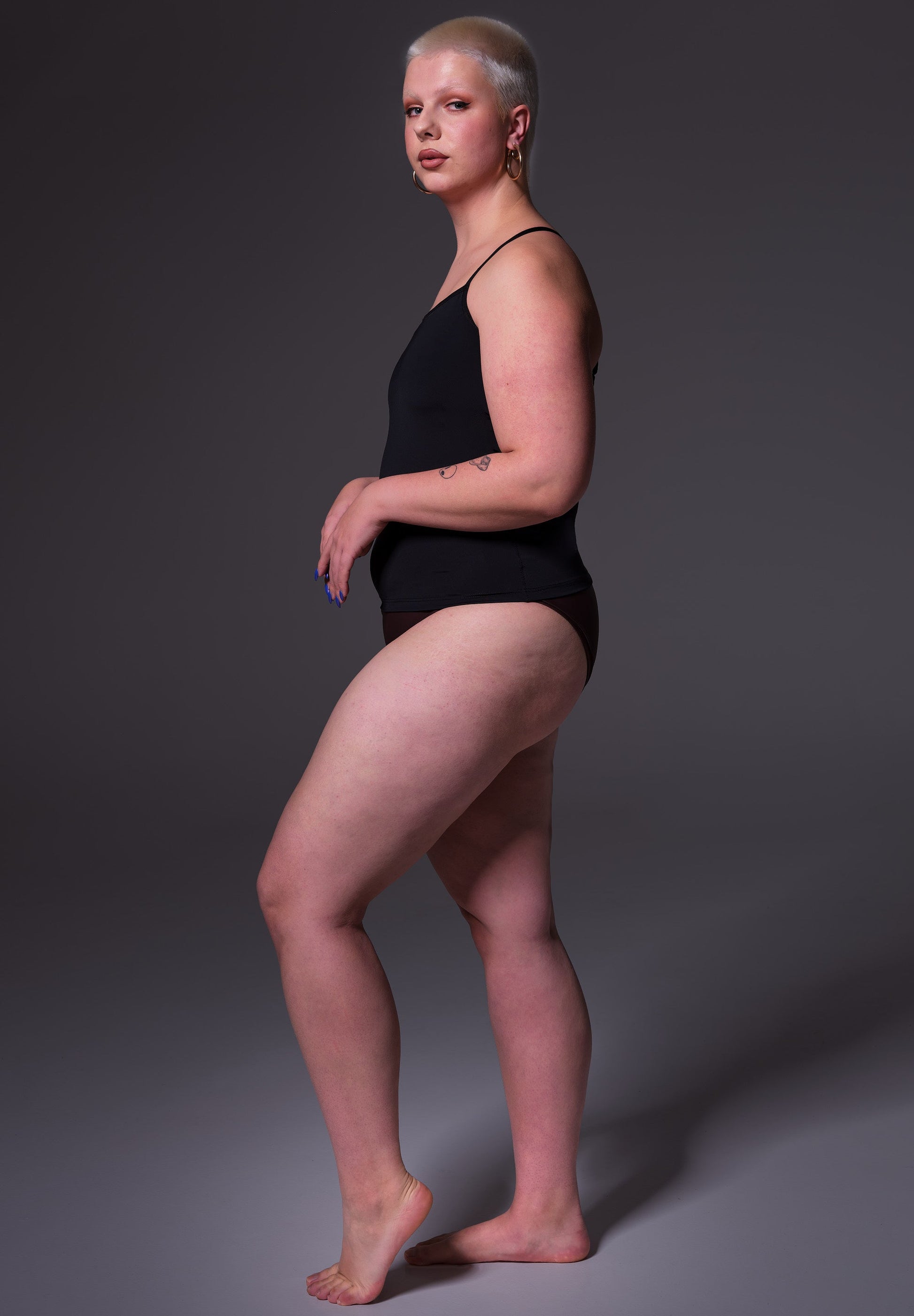 Sasha seen from the side wearing the Singlet Advanced black