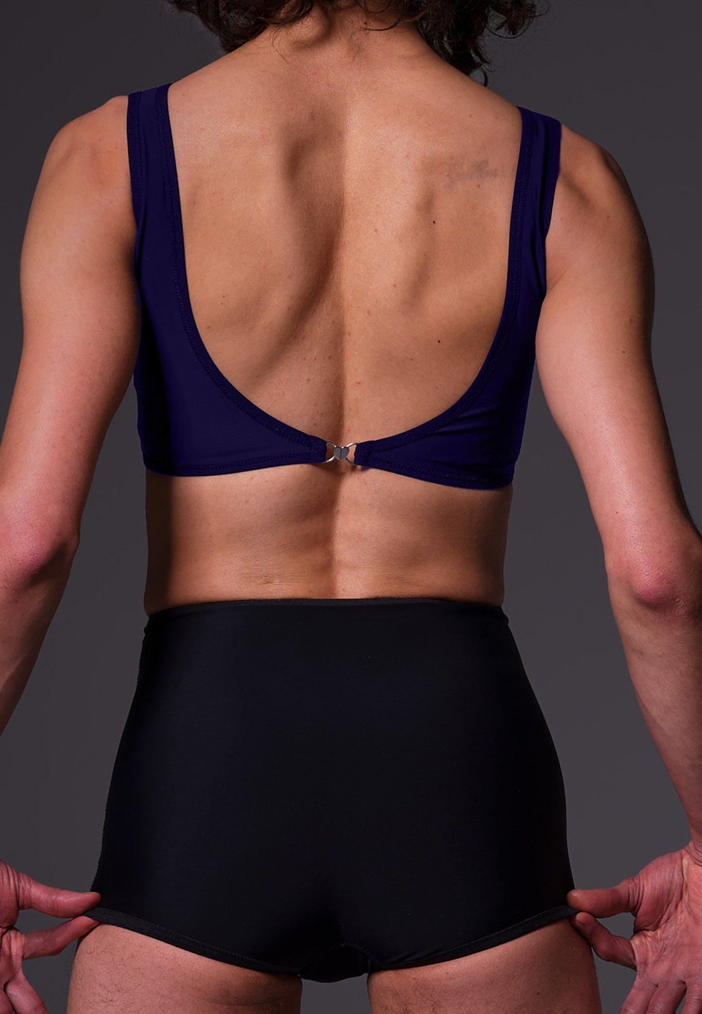 Bikinitop dark blue, seen from the back when worn by model Riah